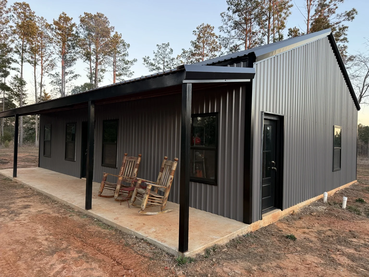 Finished dark gray barndominium with covered porch