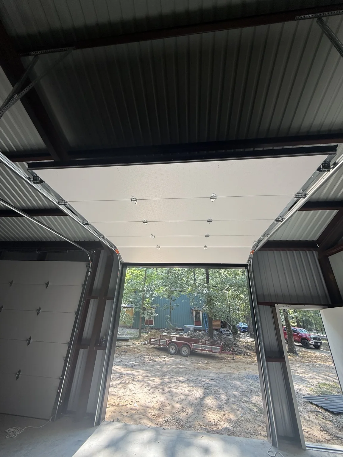 Interior view of an insulated overhead door raised on commercial tracks